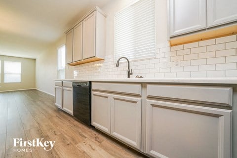 a white kitchen with white cabinets and a dishwasher in it