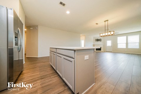 a kitchen with a large island and a stainless steel refrigerator