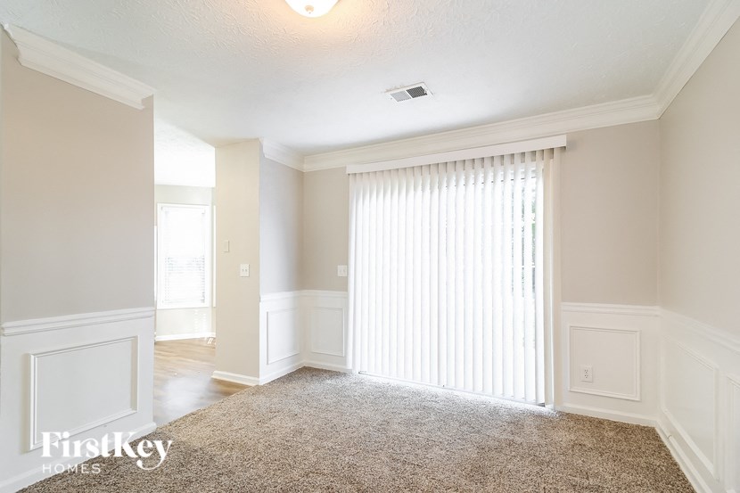 A well-lit, empty room with a carpeted floor and white walls.