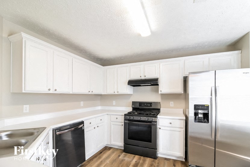 A kitchen with white cabinets and stainless steel appliances.