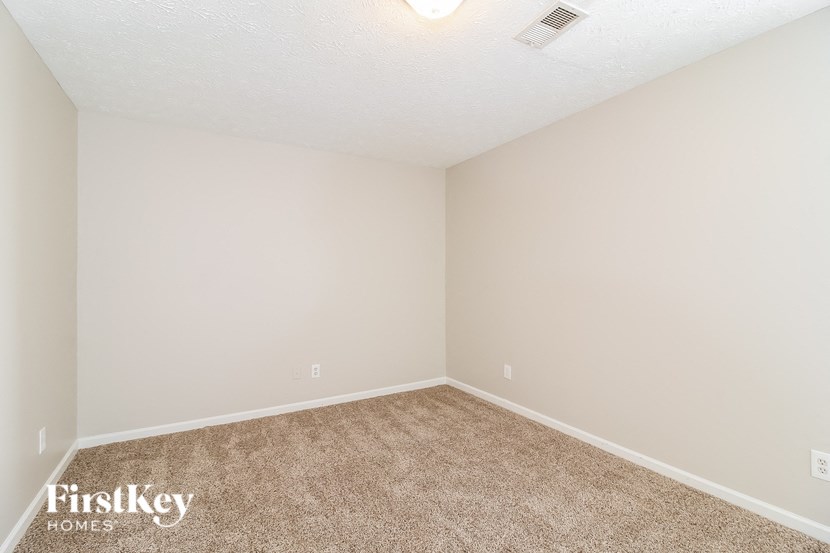 A room with a carpeted floor and a Firstkey Homes logo on the bottom left corner.