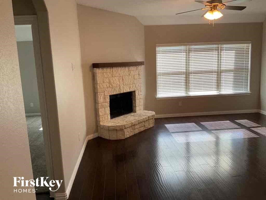 A living room with a fireplace and a fan.