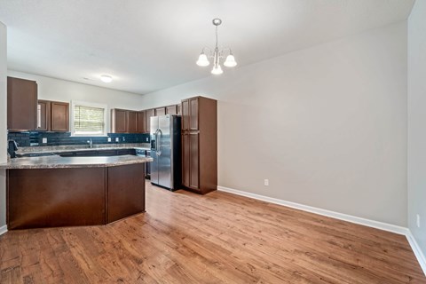 A kitchen with brown cabinets and a refrigerator.