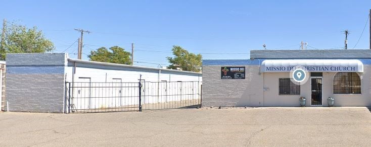 a small building with a fence and a sign on it