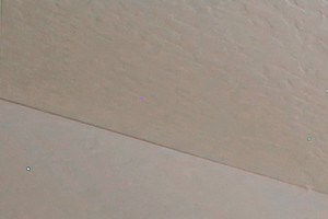 an empty living room with a ceiling fan and a window