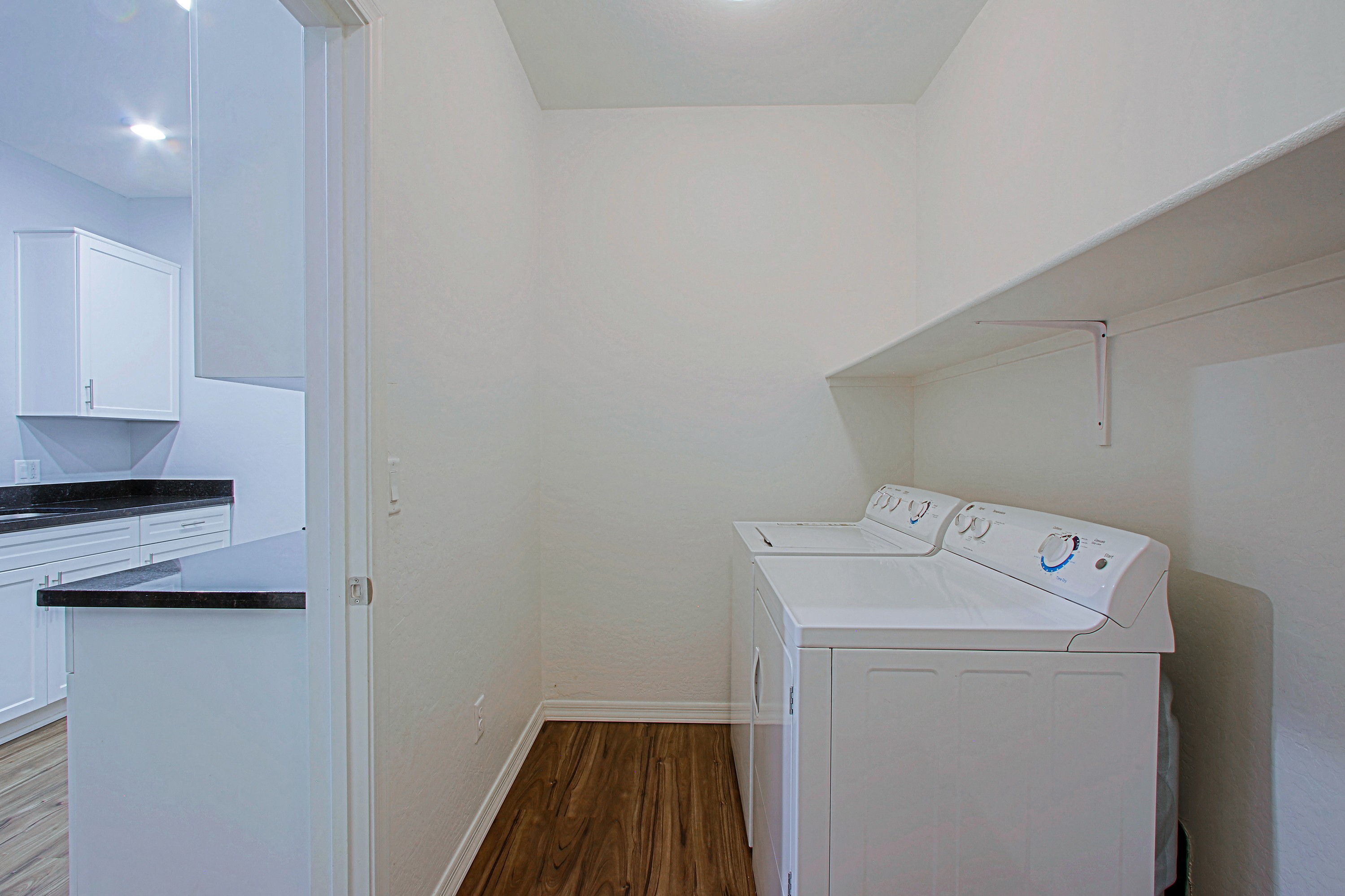 an empty laundry room with a washer and dryer in it