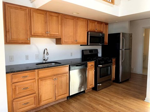 a kitchen with wooden cabinets and stainless steel appliances