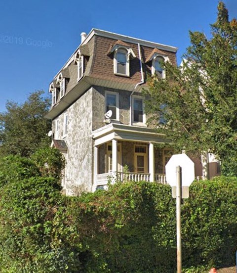A large house with a stop sign in front of it.