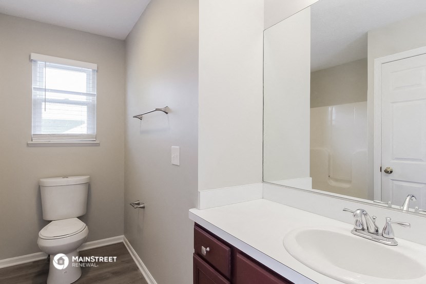 a bathroom with a mirror and a sink and a toilet