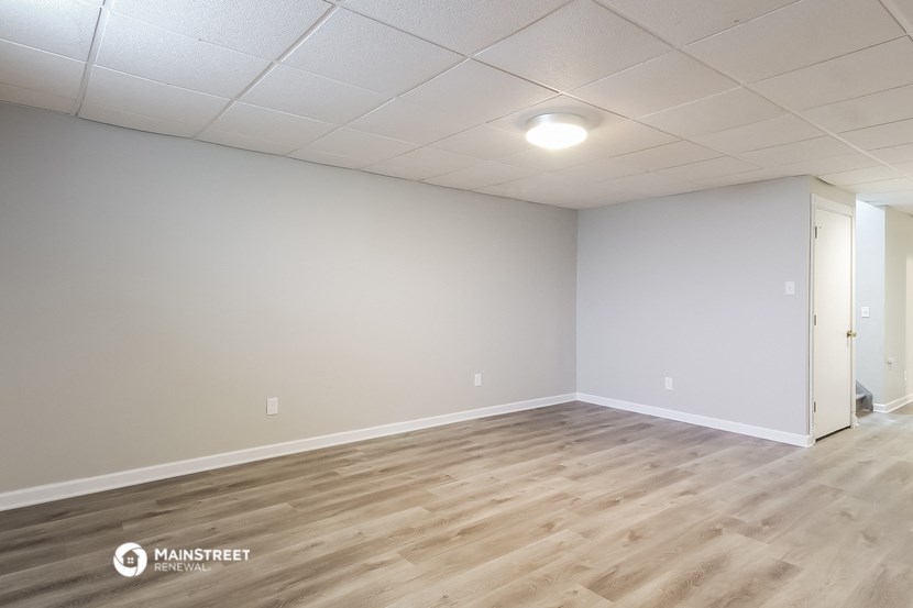the living room and dining room of a manufactured home with wood floors and white walls