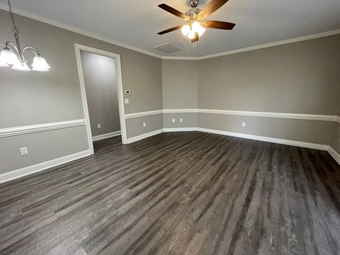 A room with a ceiling fan and a light fixture.