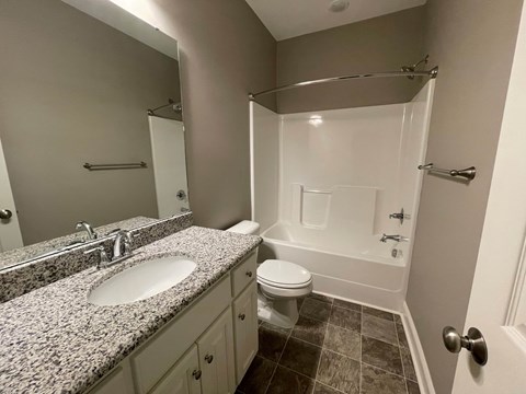 A bathroom with a sink, toilet, and bathtub.