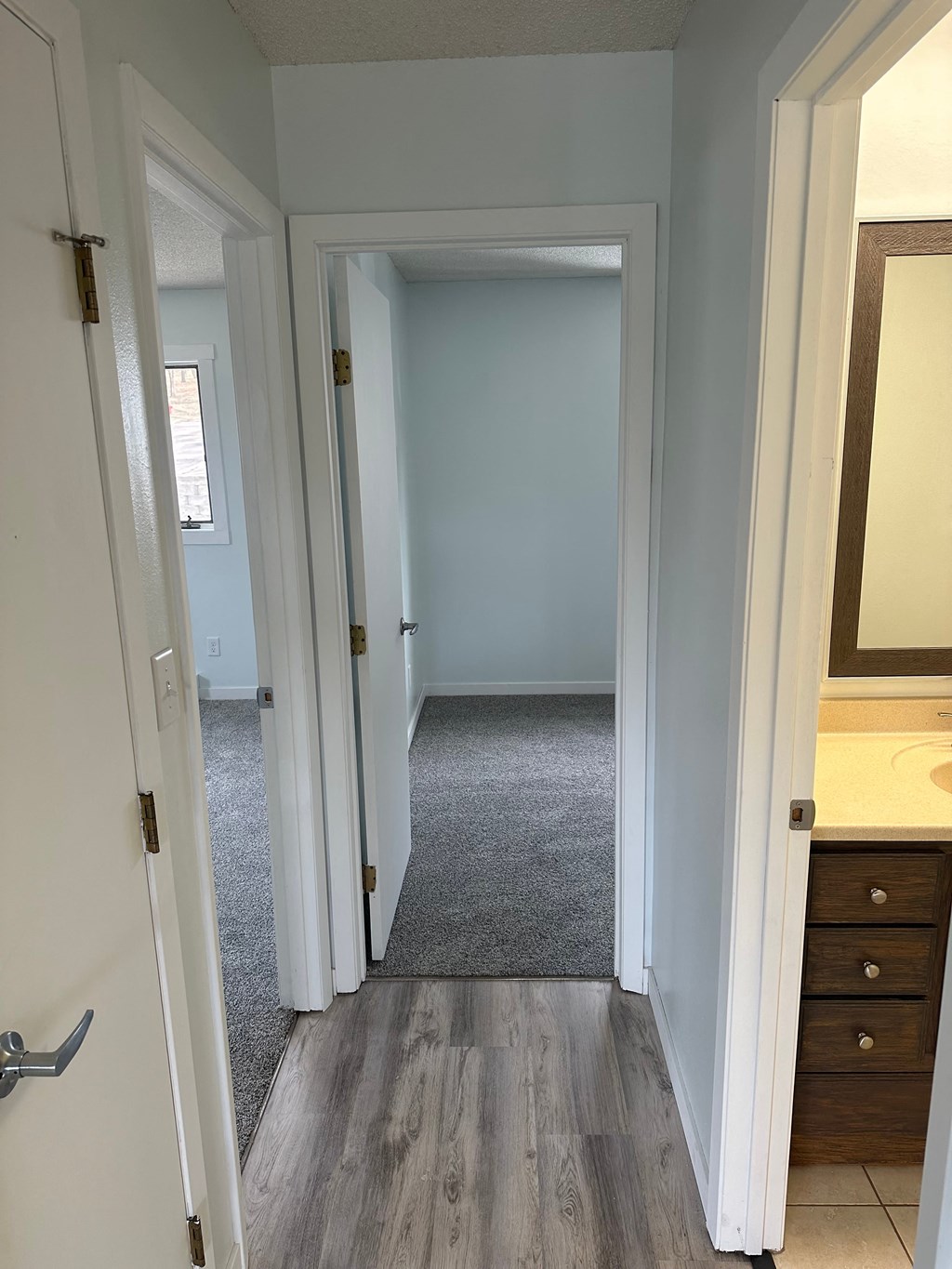 a look down the hall from the master bathroom into the bedroom and hallway to the