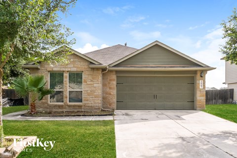 A house with a garage and a driveway in front of it.