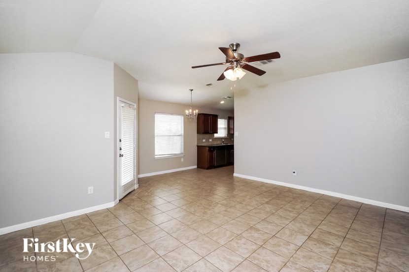 A spacious room with a ceiling fan and tiled flooring.