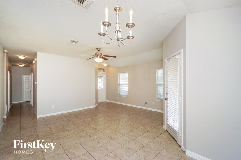 A spacious room with a chandelier and a ceiling fan.