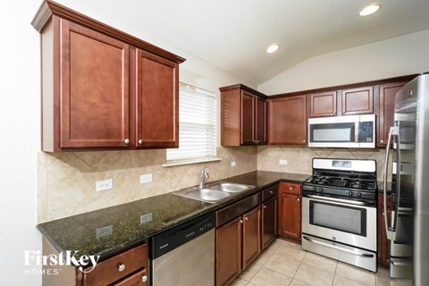A kitchen with brown cabinets and stainless steel appliances.