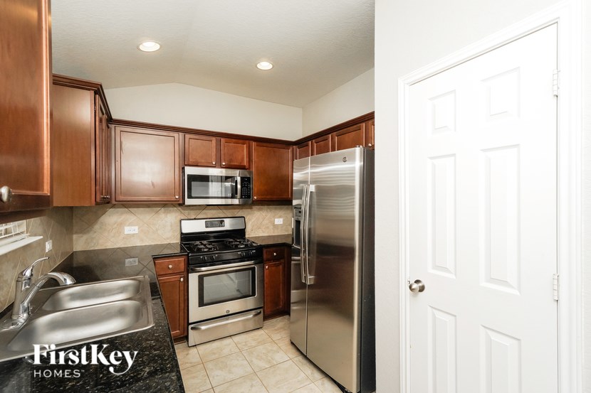 A kitchen with a sink, stove, and refrigerator.