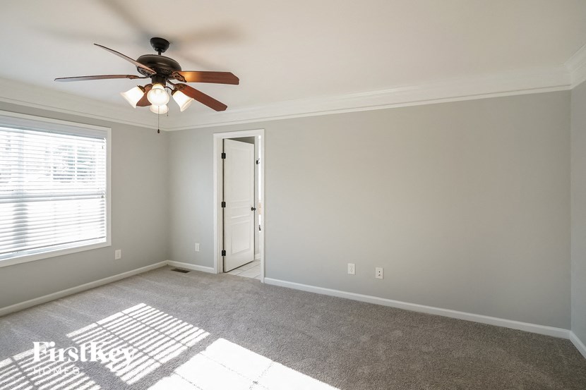a living room with a ceiling fan and a door
