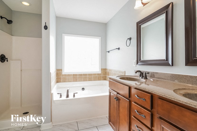 a bathroom with a tub and a sink and a mirror