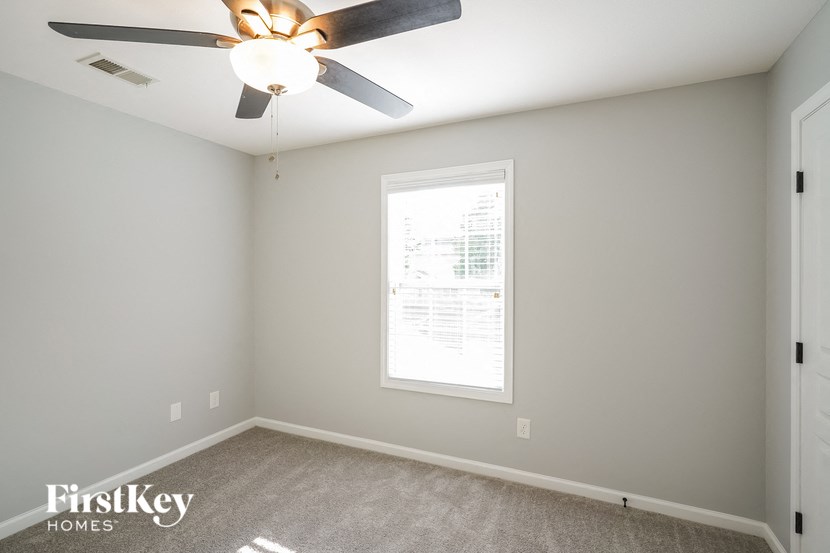 a bedroom with a ceiling fan and a window