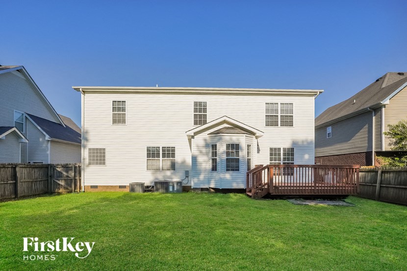 a white house with a backyard and a deck