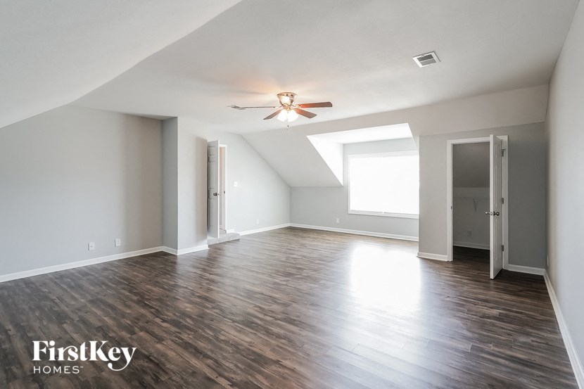 an empty living room with white walls and a ceiling fan