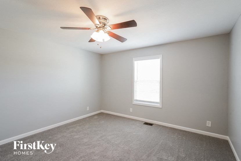 a bedroom with a ceiling fan and a window
