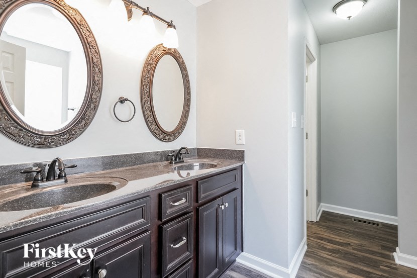 a bathroom with two sinks and two mirrors