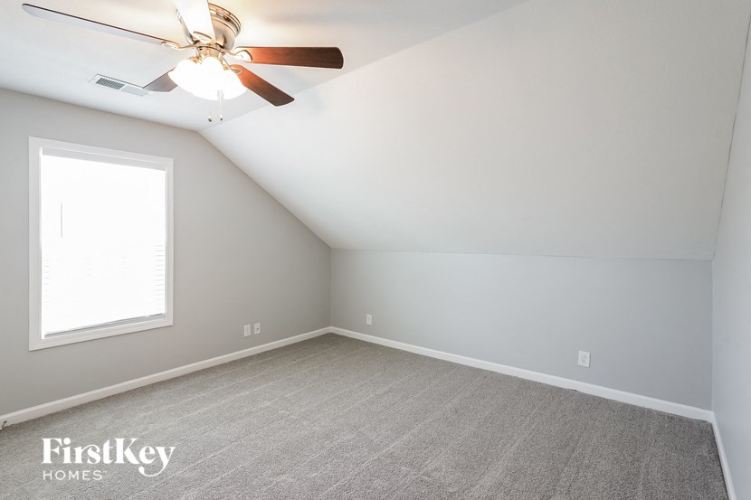 a bedroom with a ceiling fan and a window
