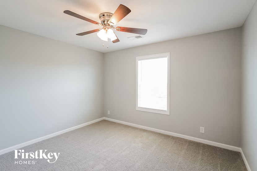 a bedroom with a ceiling fan and a window