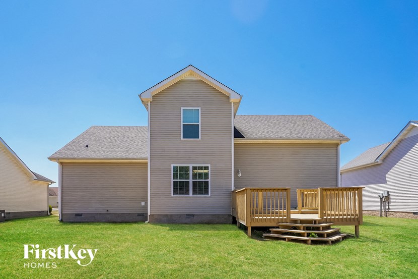 a house with a porch and a deck on the grass