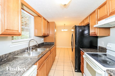 A kitchen with wooden cabinets and black appliances.