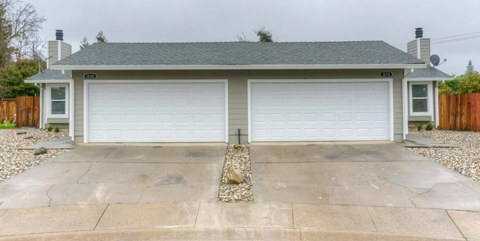 A two-car garage with a concrete driveway in front.