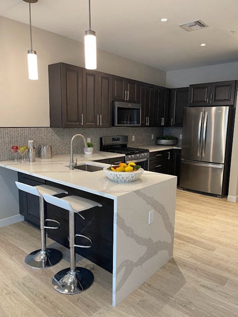 a kitchen with a large island with two stools