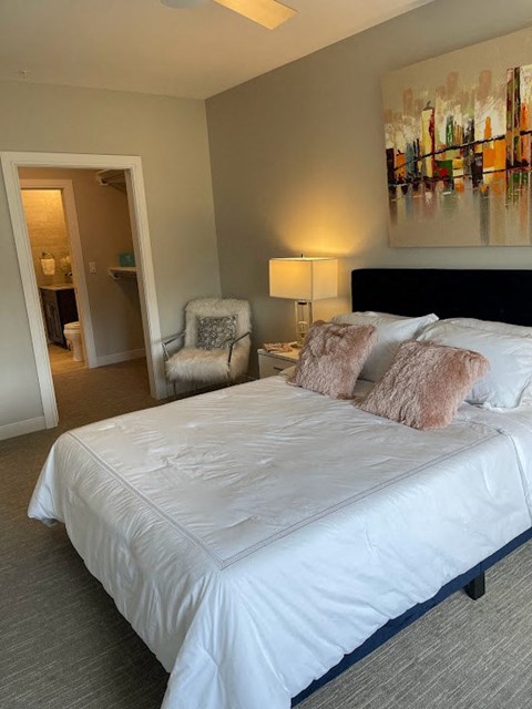 a bedroom with a white bed and a chair