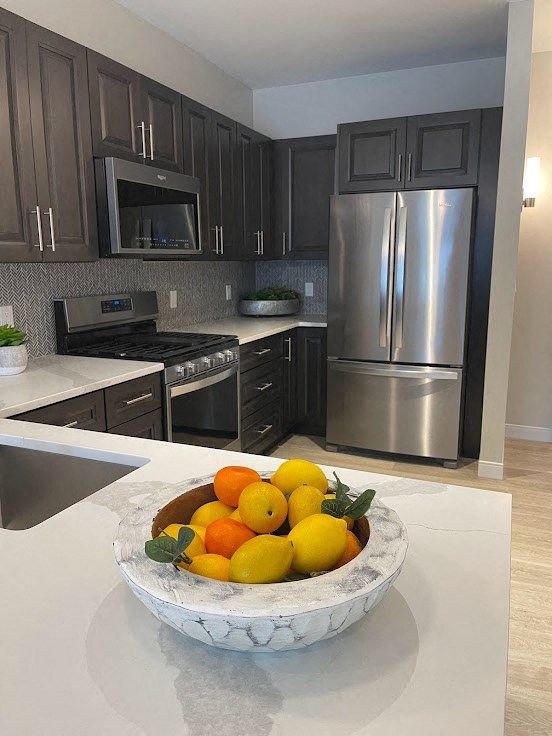 a bowl of fruit on a counter in a kitchen