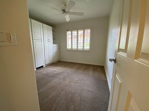 a bedroom with a ceiling fan and a closet