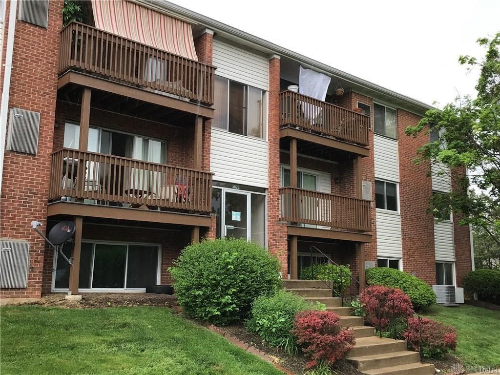 A red brick building with a white door and windows.