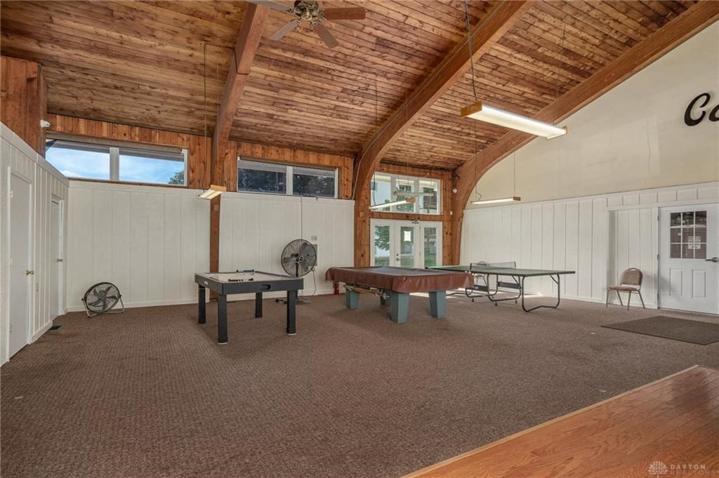 A room with a wooden ceiling and a long table with chairs.