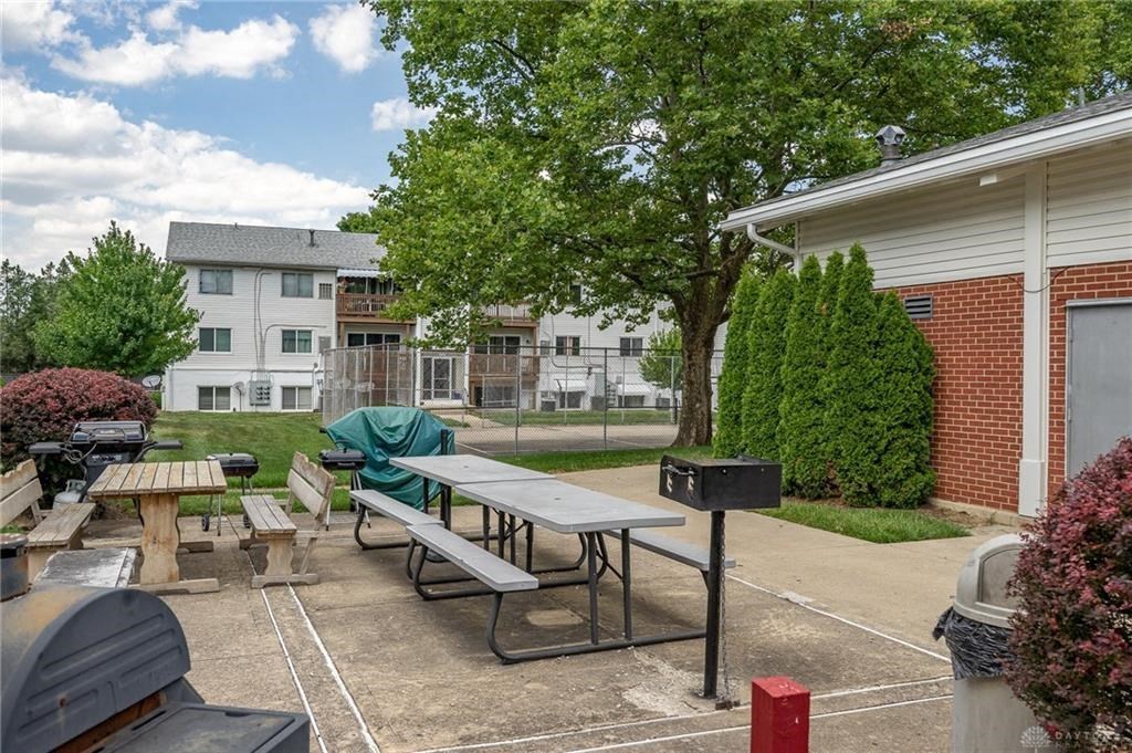 A sunny day at a picnic area with tables and benches.