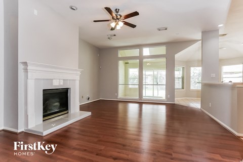 A spacious living room with a fireplace and wood flooring.
