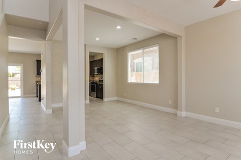 A spacious living room with a kitchen in the background.