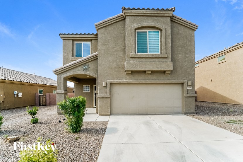 A house with a garage and a driveway in front.