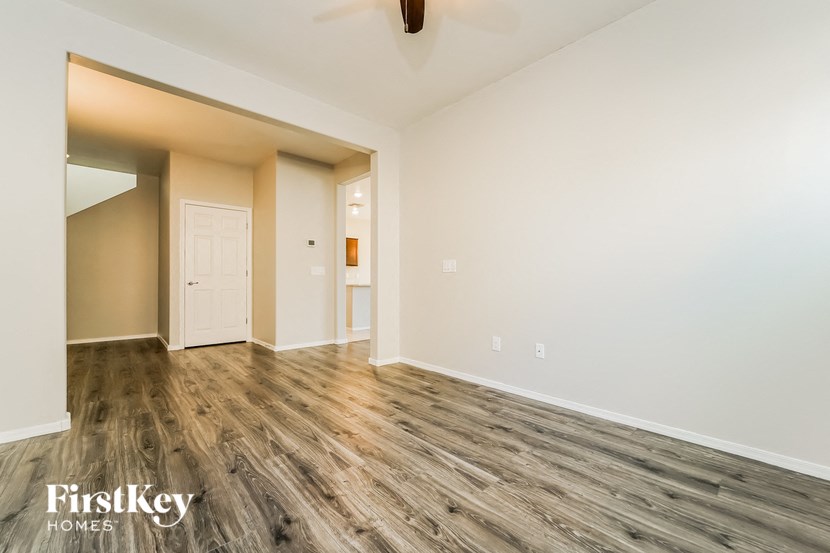 A room with wooden flooring and a ceiling fan.