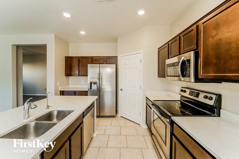 A kitchen with a stove top oven and a refrigerator.
