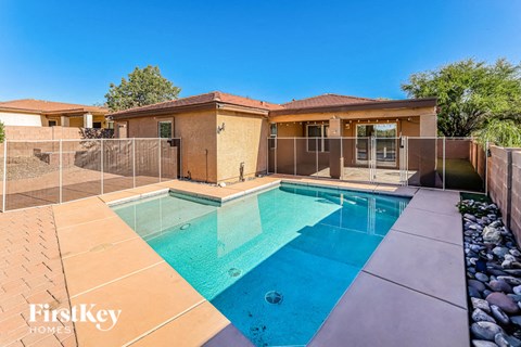 A swimming pool in a backyard with a house in the background.