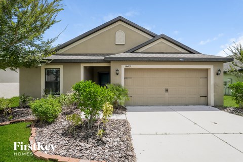 A house with a garage and a driveway in front of it.
