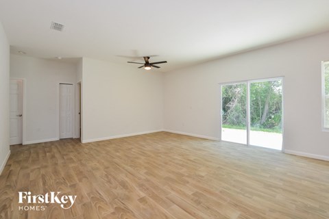 A spacious room with a ceiling fan and wooden flooring.