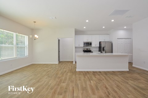 A kitchen with wooden floors and white walls.